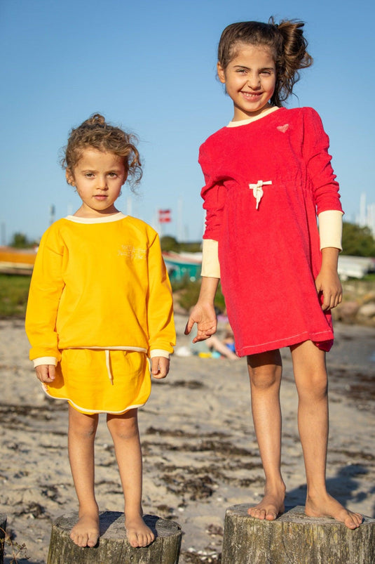 Two girls wearing organic cotton sets in bright colours