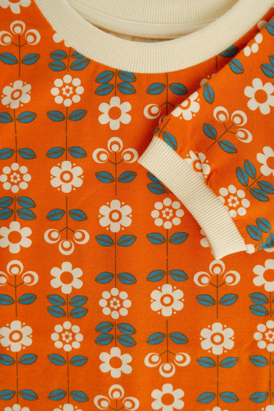 sleeve detail of retro blouse for children in orange with flowers