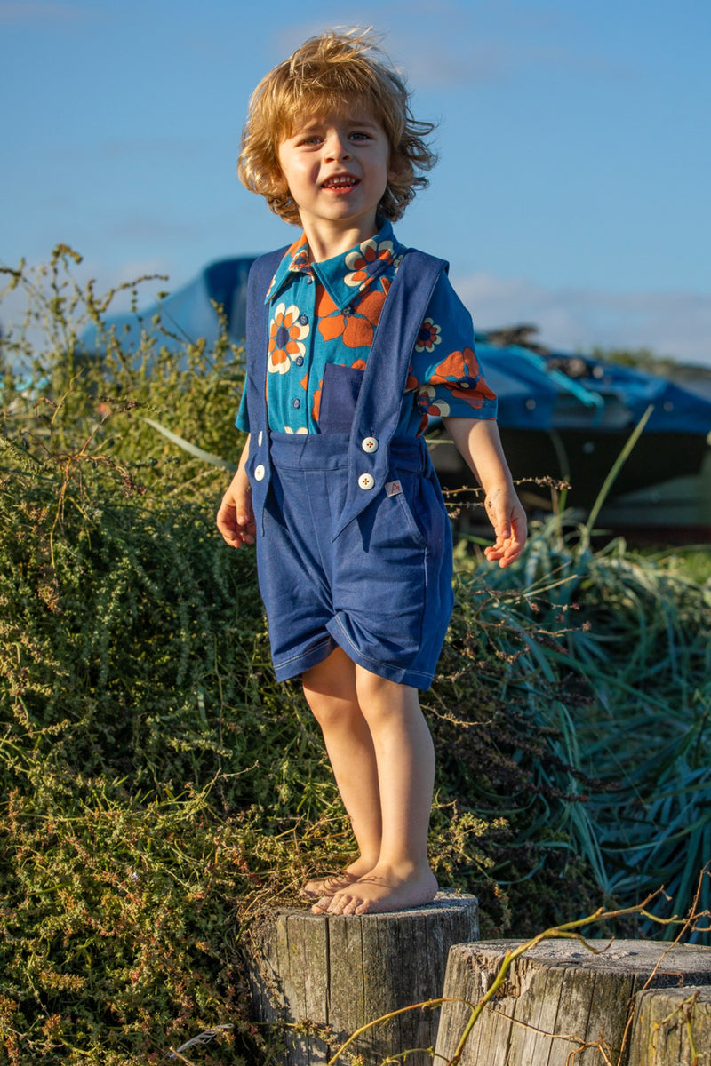 Load image into Gallery viewer, Kid wearing a Retro looking shirt for kids in bright blue and orange haway flowers
