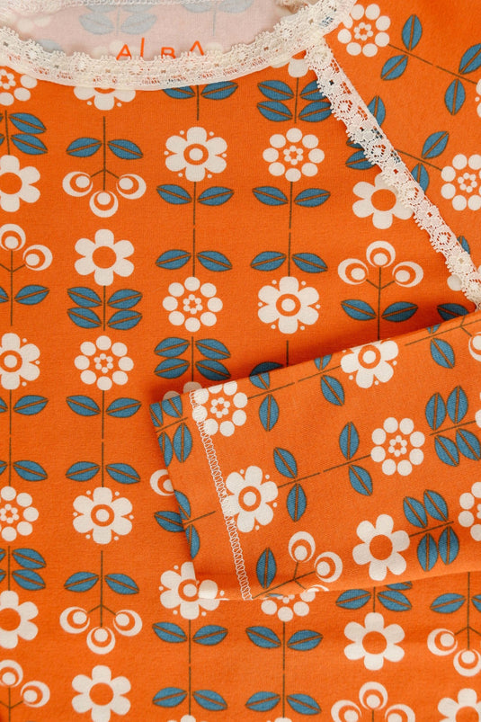 Detail of retro orange blouse with small white flowers in organic cotton for girls