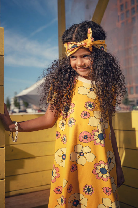 Danish girl wearing a Retro yellow dress in organic cotton and big flowers