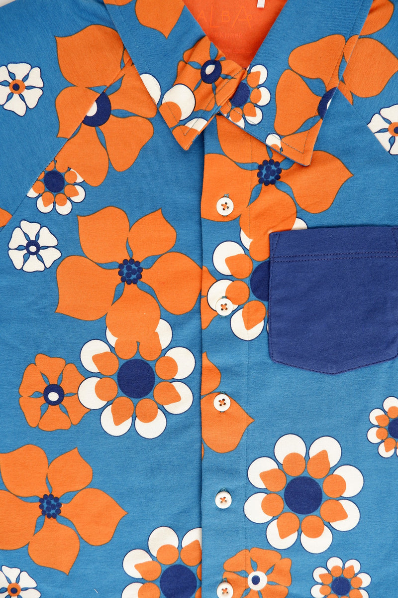 Load image into Gallery viewer, Pocket detail of the Retro looking shirt for kids in bright blue and orange haway flowers
