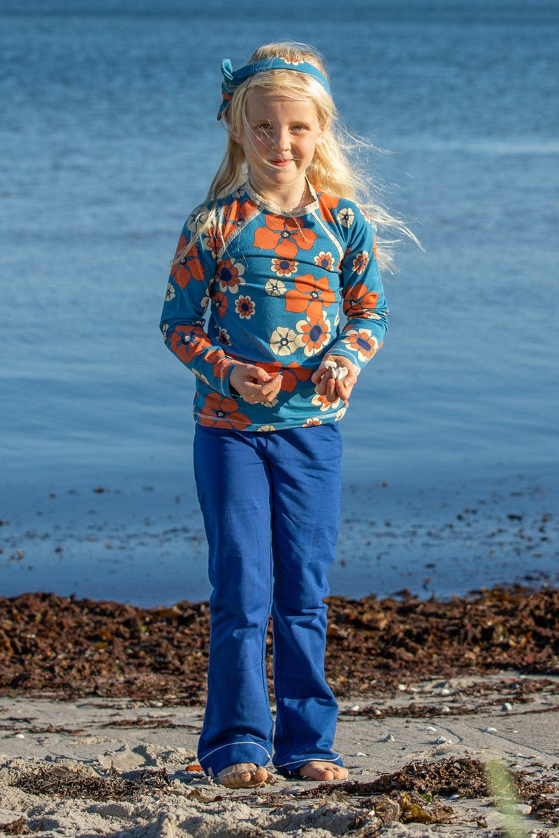 Load image into Gallery viewer, Danish girl wearing githa blouse in organic cotton for children in bright blue and orange flowers
