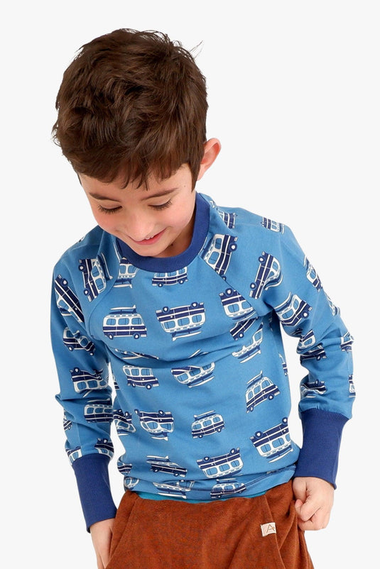 Child wearing blue organic t-shirt with long arms and boat print
