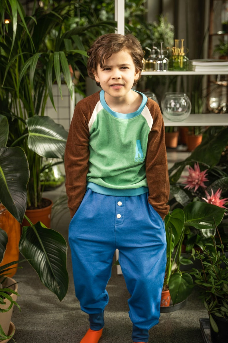 Load image into Gallery viewer, Danish kid wearing button pants in bright blue for children in organic cotton
