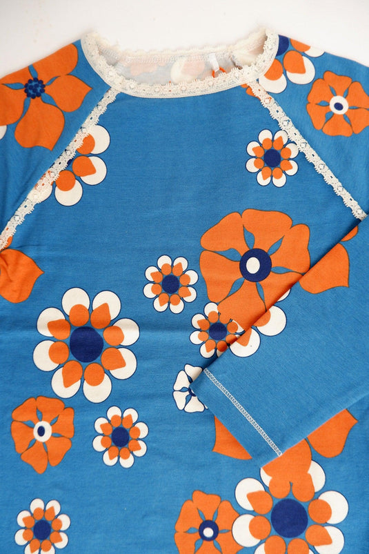 Detail of the githa blouse in organic cotton for children in bright blue and orange flowers