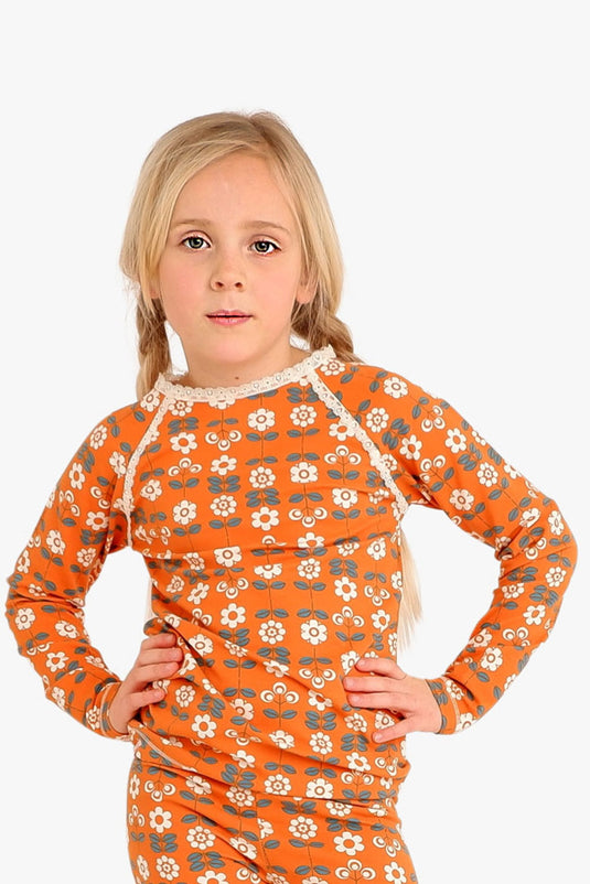Scandinavian girl wearing retro orange blouse with small white flowers in organic cotton