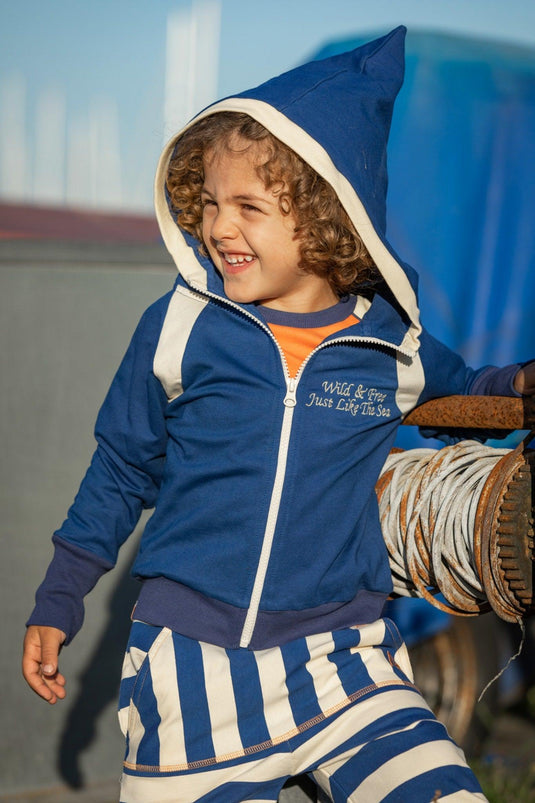 Scandinavian child wearing organic soft pointed hood and mason striped pants