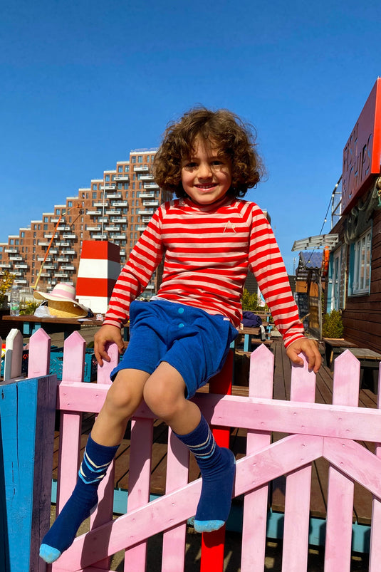 boy wearing Organic t-shirt with long arms in red breton stripes