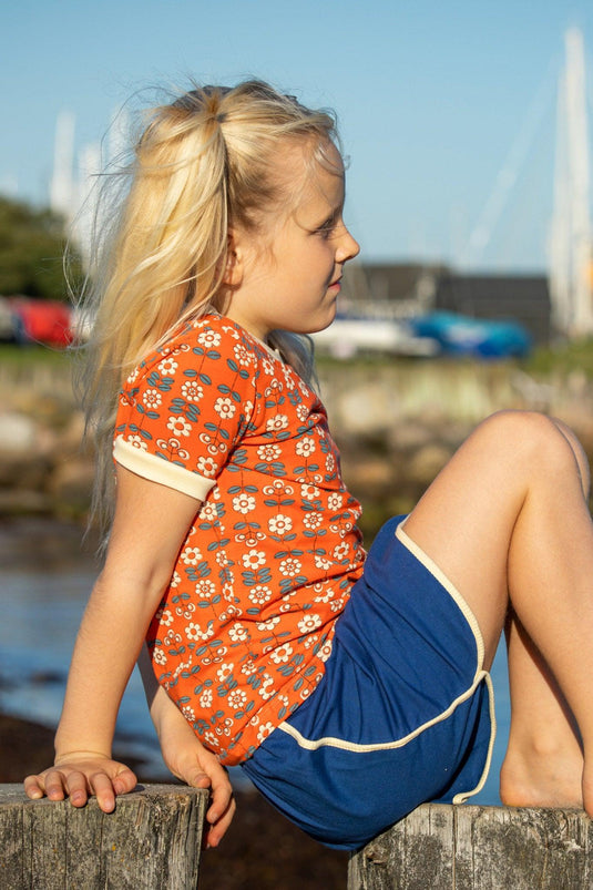 Scandinavian girl wearing retro blouse for children in orange with flowers