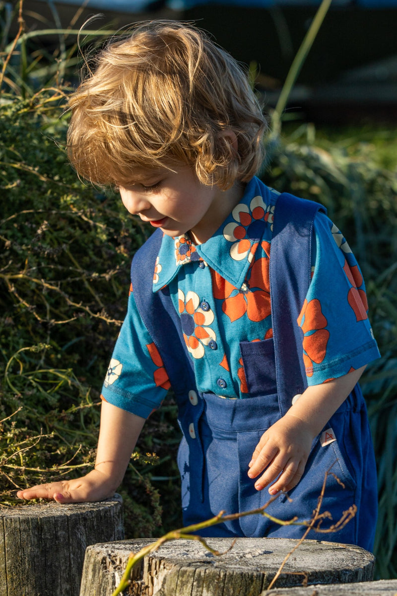 Load image into Gallery viewer, Child wearing a Retro looking shirt for kids in bright blue and orange haway flowers
